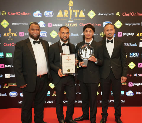 Four Spice Merchants representatives in black tie holding the ARTA 2026 trophy and certificate in front of the sponsors' media wall.